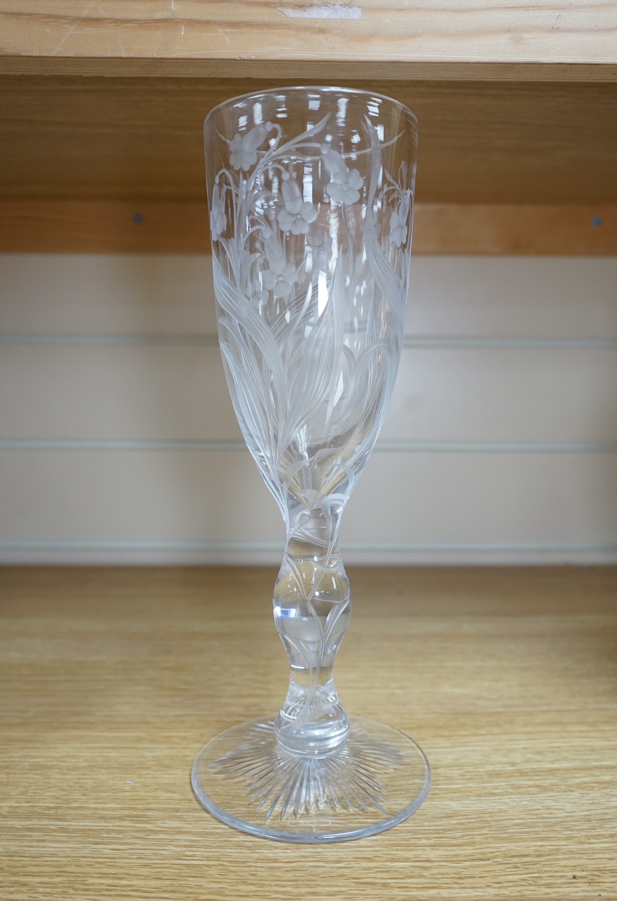 A large ‘floral’ engraved glass flute, 29.5cm. Condition - chip to upper rim